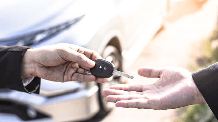 Two hands passing a car key between themselves