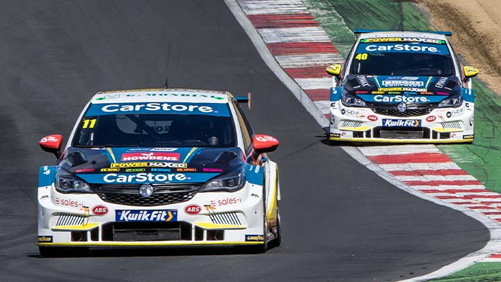 Two liveried CarStore PMR Vauxhall Astras racing around Brands Hatch
