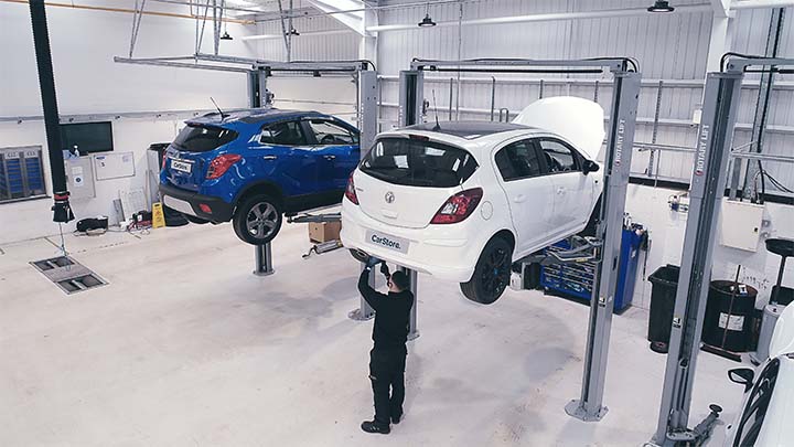 CarStore workshop with technician working on Vauxhall Corsa