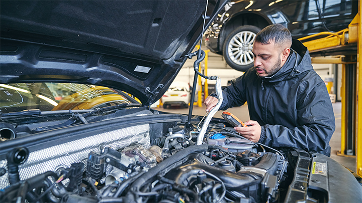 Technician performing a repair on a car